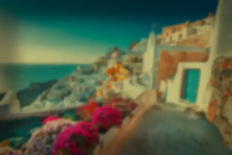 A coastal village of whitewashed buildings and bright flowers, seen through eyes with cataracts: blurred, dimmed and clouded by a yellow-brown haze